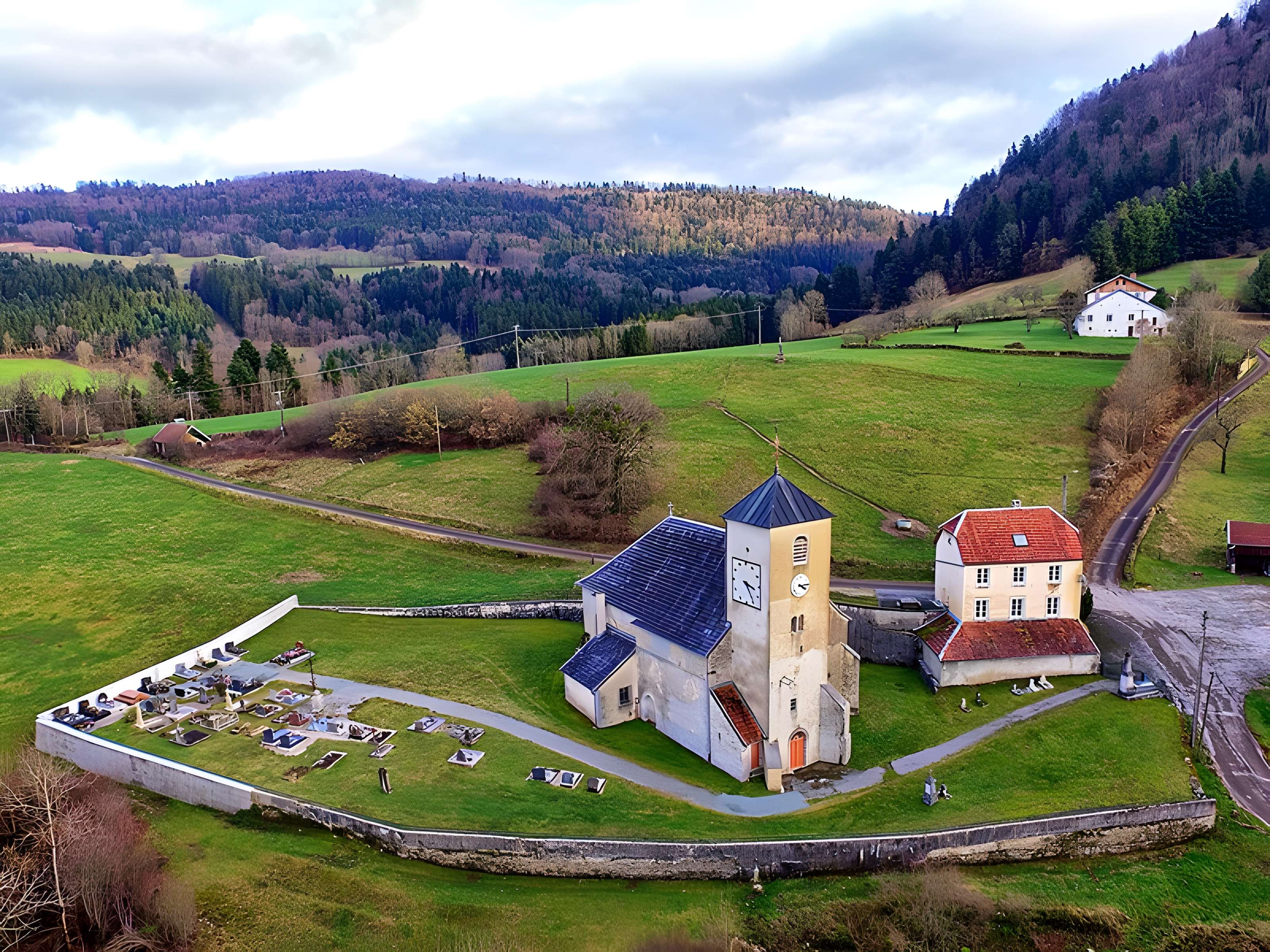 Église Saint-Sulpice de Laval-le-Prieuré et une croix