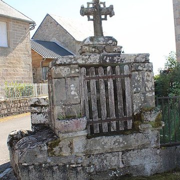 Croix du XVe siècle placée sur le mur de clôture de lécole