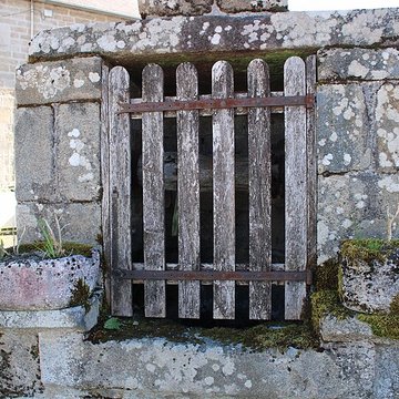 Croix du XVe siècle placée sur le mur de clôture de lécole
